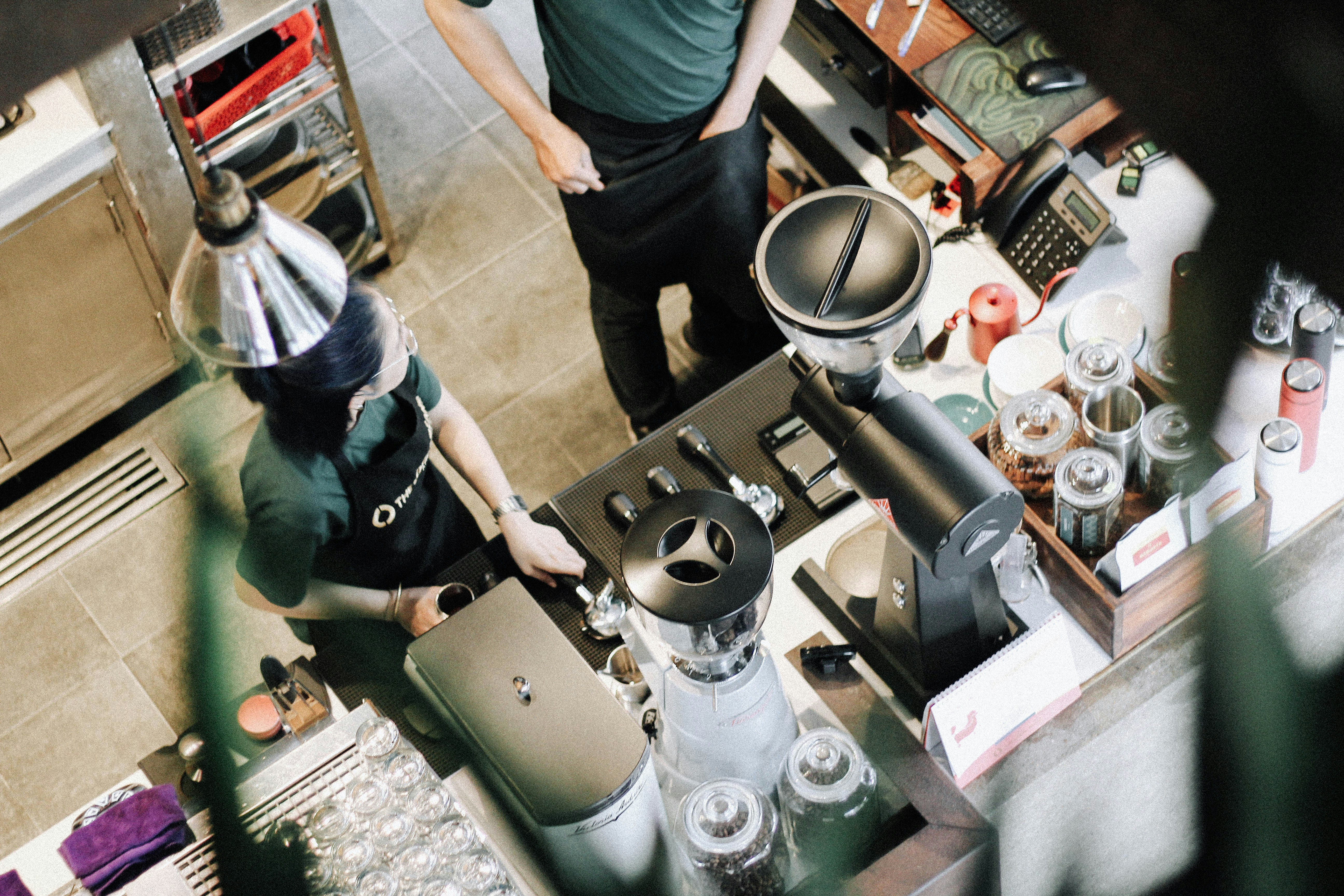 Bartenders are surrounding the bar in a coffee shop.