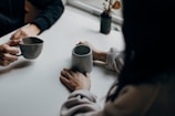 Picture of a friendly conversation between colleagues at a desk with coffee cups