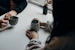 two people holding gray mugs at table