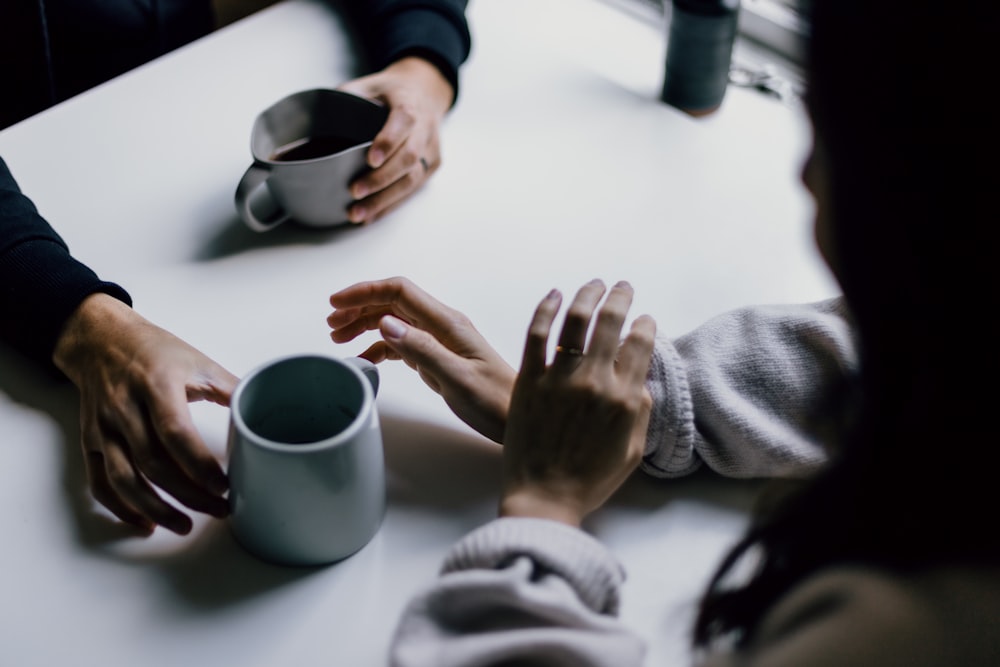 Un grupo de personas sentadas alrededor de una mesa blanca