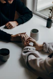 two people holding hands at table