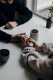 two people holding hands at table