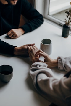 Couple holding hands during a therapy session in a cozy room.