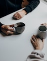 a couple of people sitting at a table with cups of coffee