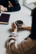 woman holding gray mug at table
