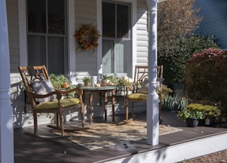 brown wooden chairs and table near white wooden post