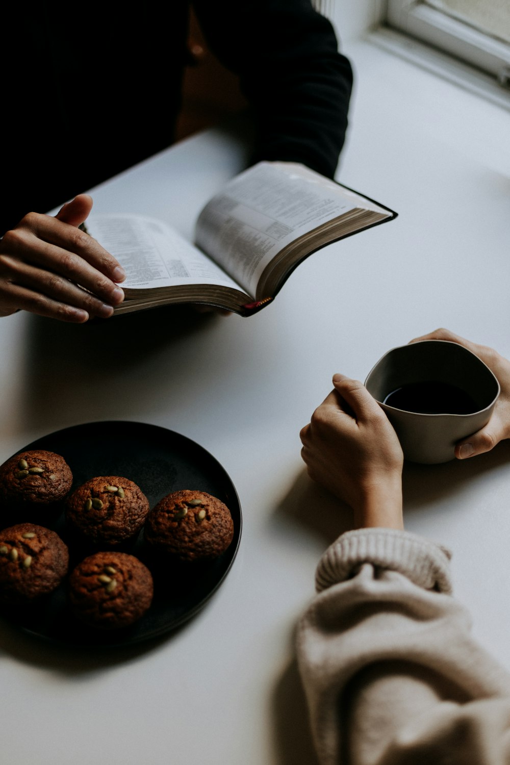 personne tenant une tasse en céramique blanche avec du café