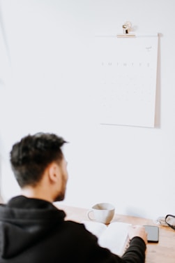 a man sitting at a desk with a cup of coffee