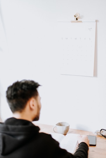 a man sitting at a desk with a cup of coffee