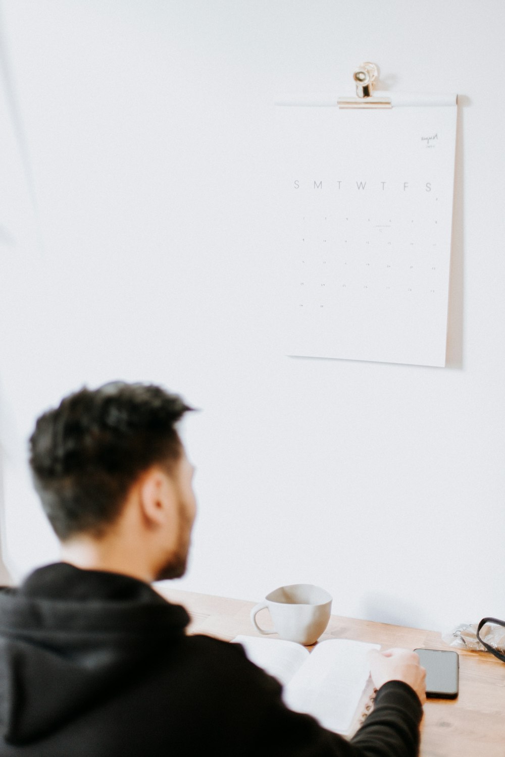 a man sitting at a desk with a cup of coffee