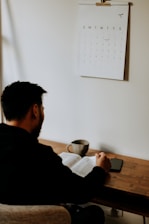 man in black long sleeve shirt sitting at the table