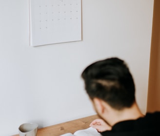 a man sitting at a desk with an open book