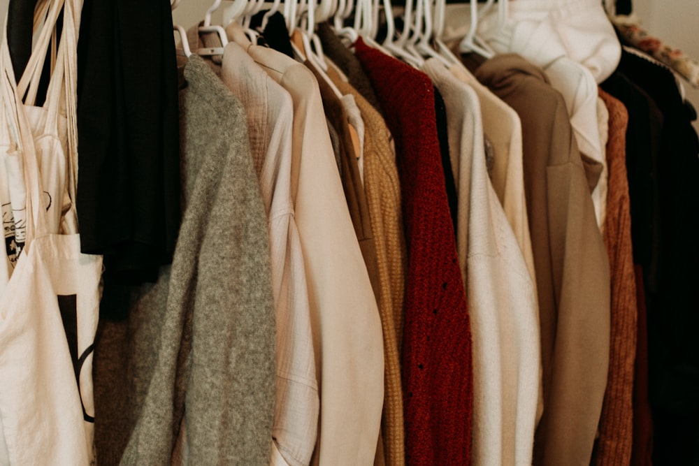 abrigo marrón y blanco colgado en el estante