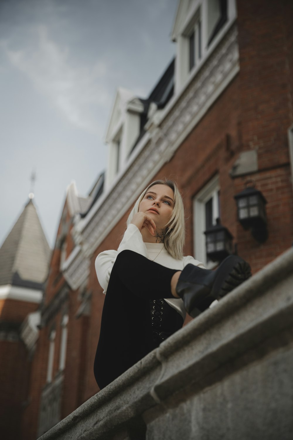 a woman leaning on a wall with her hand on her head