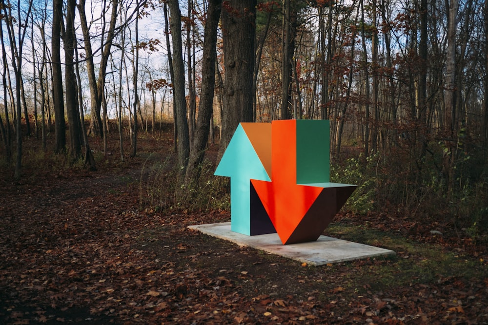 red and blue arrow sign surrounded by brown trees