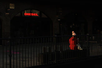 A sleek black jacket from atelier lumina draped over a modern city bench at dusk