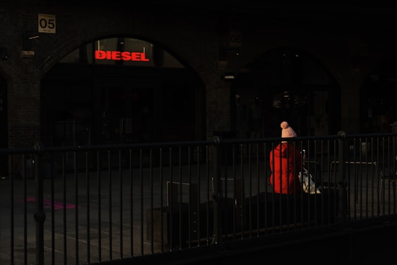 A close-up shot of a Lumina Apparel jacket draped over a sleek urban bench, sunlight casting soft shadows.