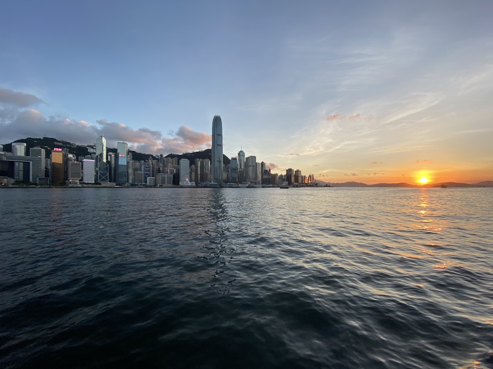 city skyline across body of water during sunset