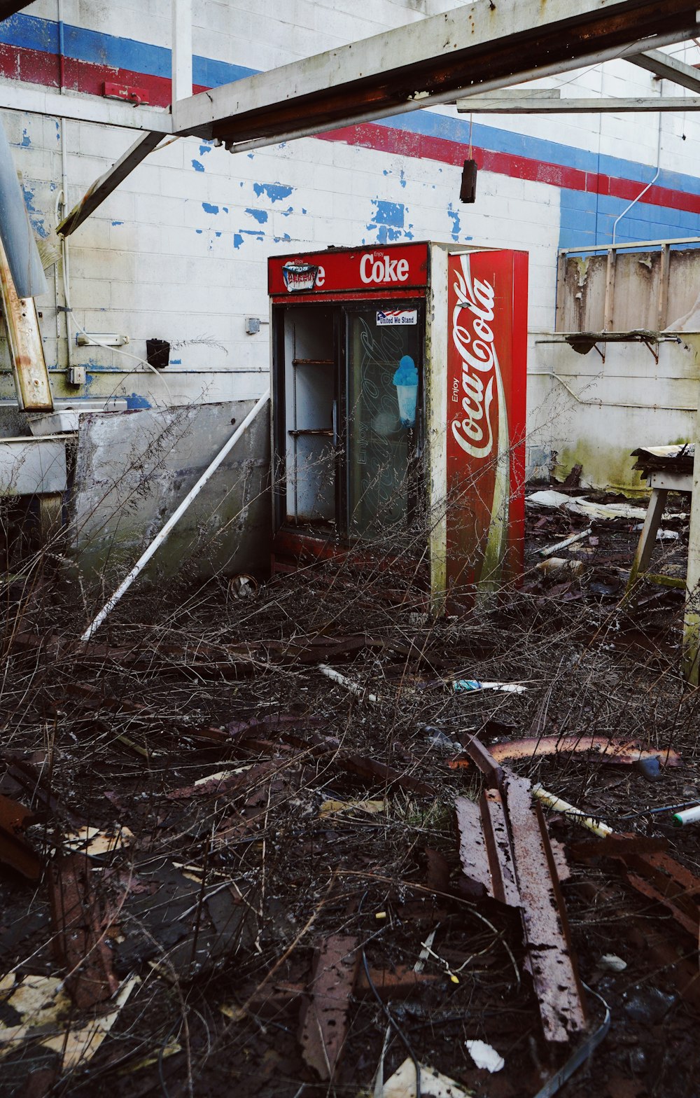 coca cola vending machine beside white wall