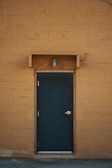 blue wooden door on brown brick wall