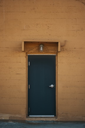 blue wooden door on brown brick wall