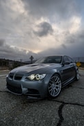 black bmw m 3 coupe on road under gray clouds