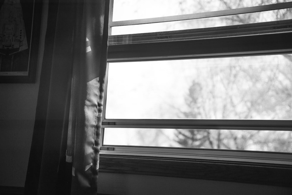 grayscale photo of window curtain