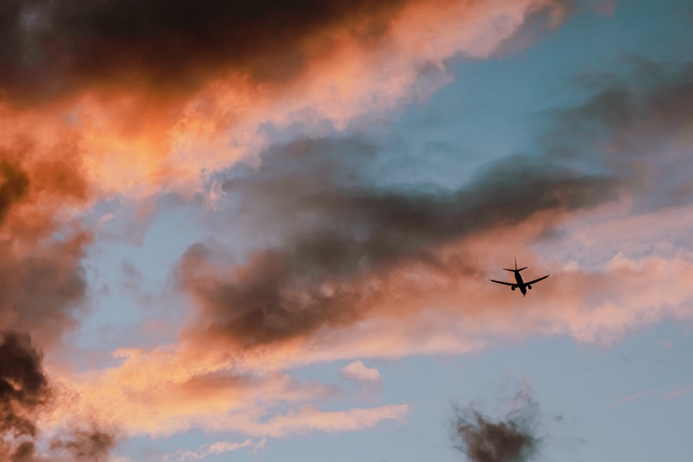 Flugzeug fliegt während des Sonnenuntergangs am Himmel