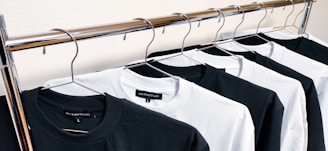 black crew neck shirt on white plastic clothes hanger