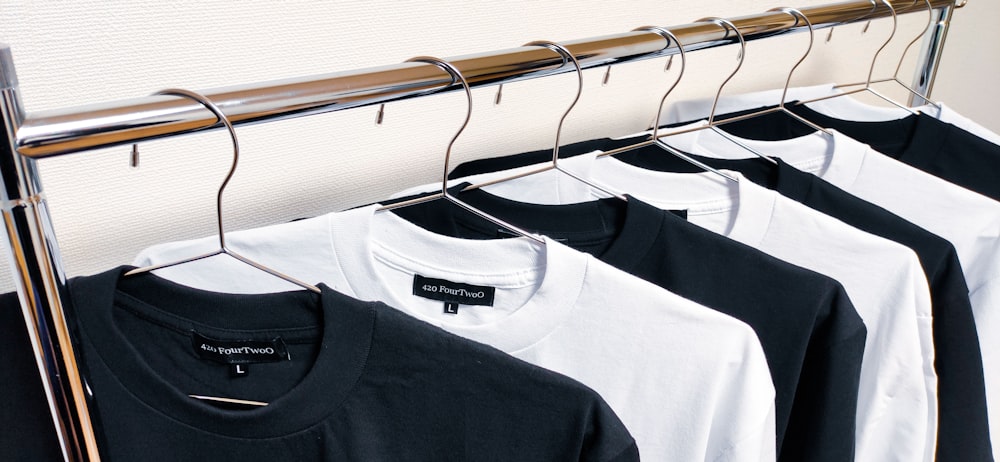 black crew neck shirt on white plastic clothes hanger