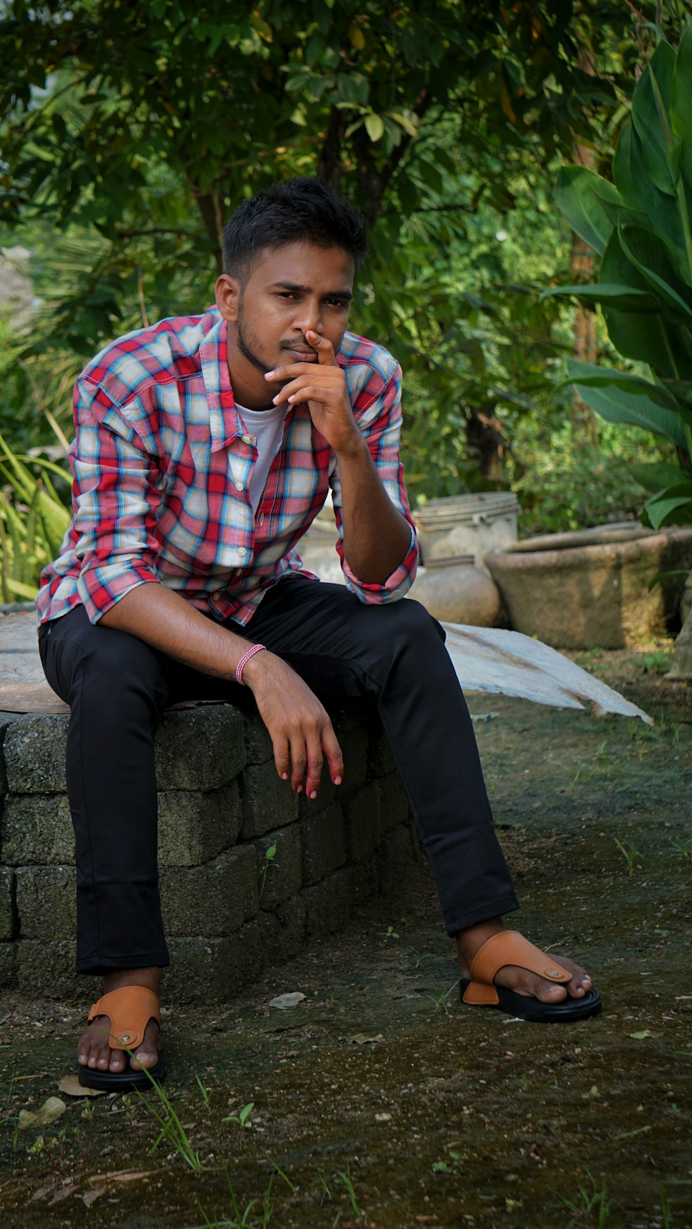 man in red white and blue plaid button up shirt sitting on concrete bench