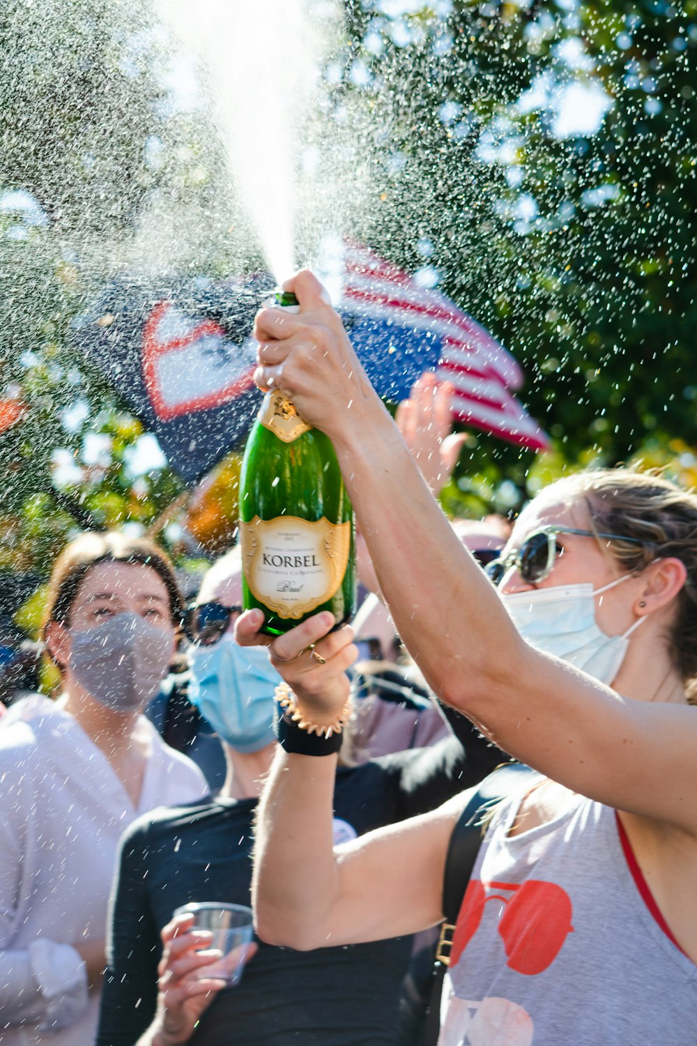 people holding green glass bottle during daytime