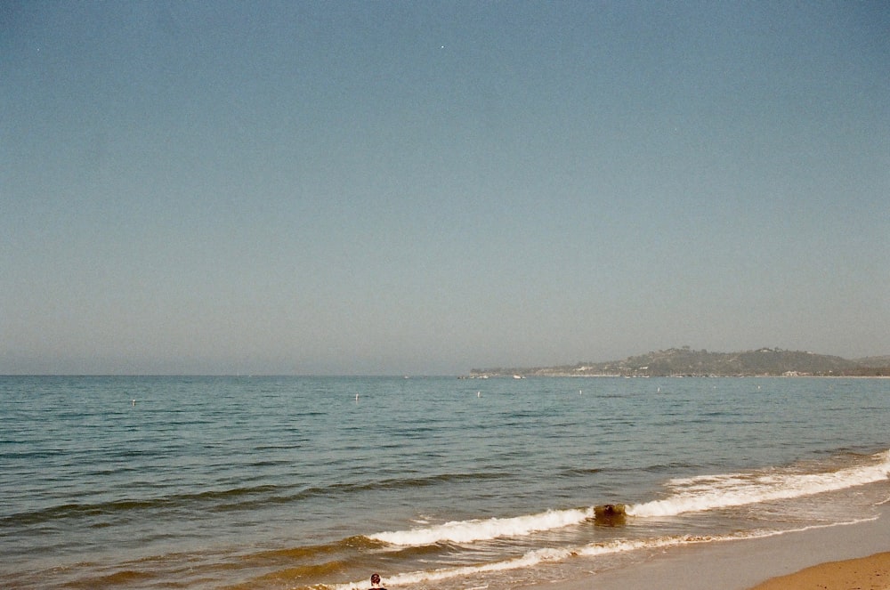 person in black shirt walking on beach during daytime