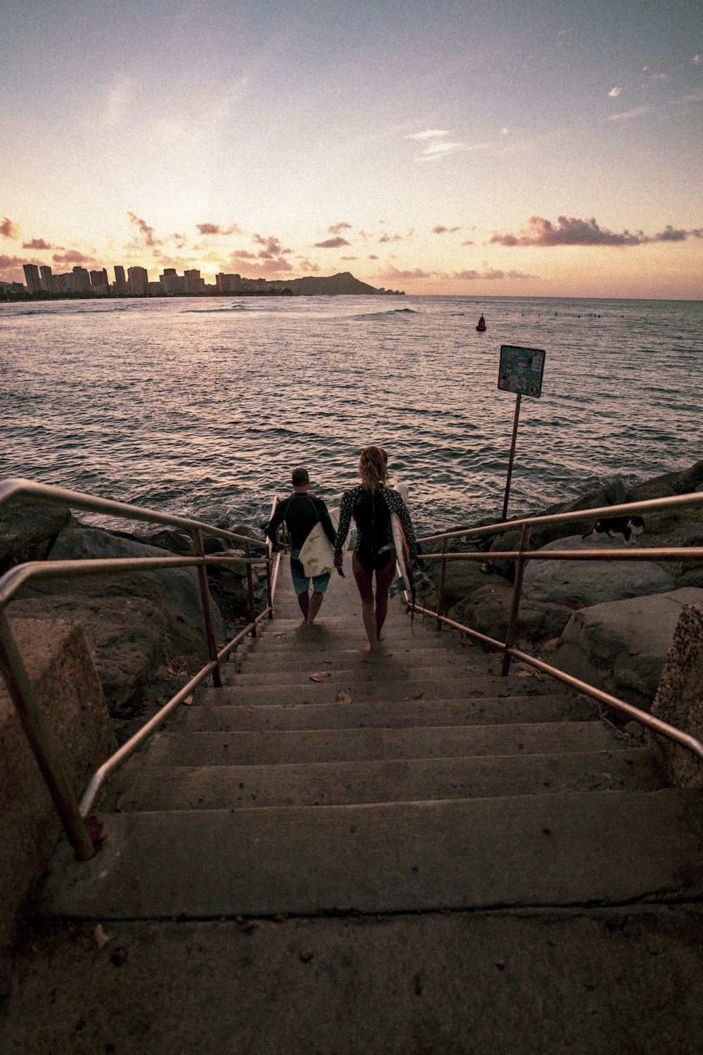 woman in black tank top and black shorts walking on wooden dock during daytime