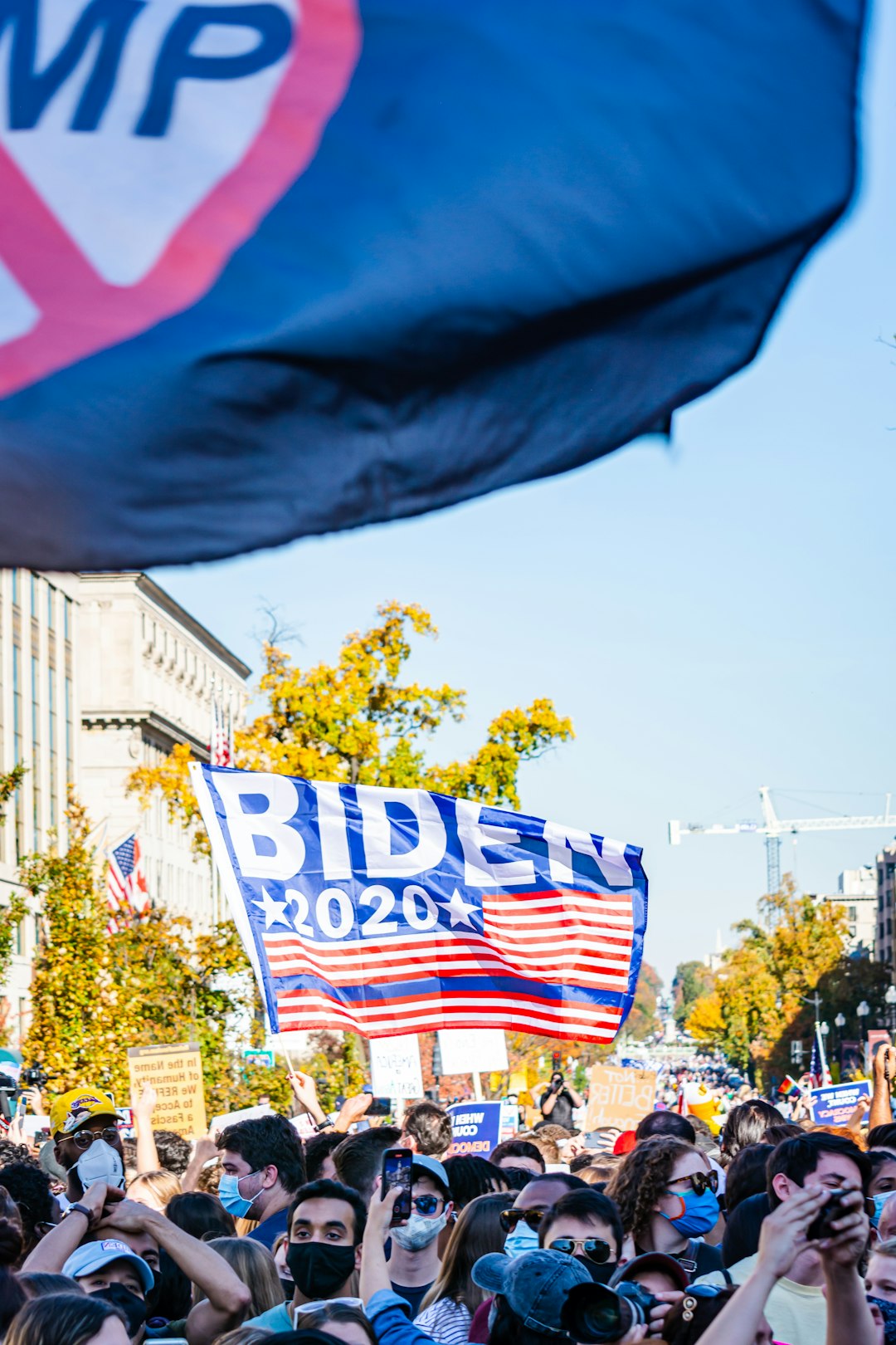 white and blue flag near green trees during daytime