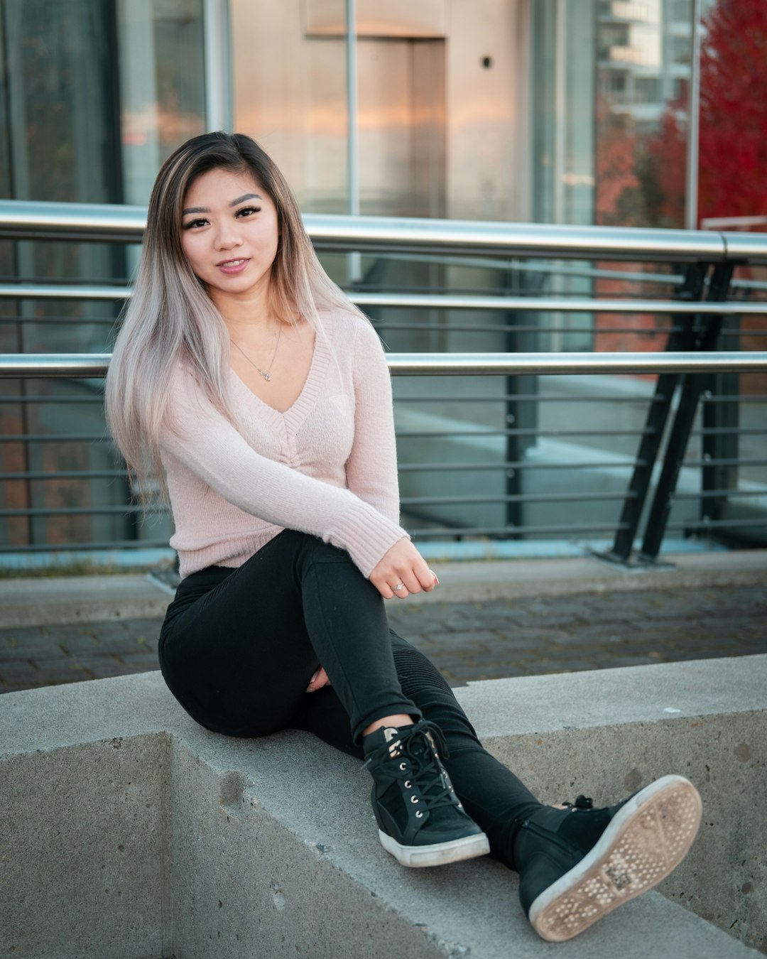 woman in white sweater and black pants sitting on concrete stairs