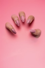 persons hand on pink surface