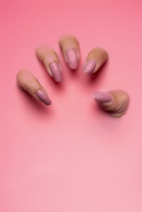persons hand on pink surface