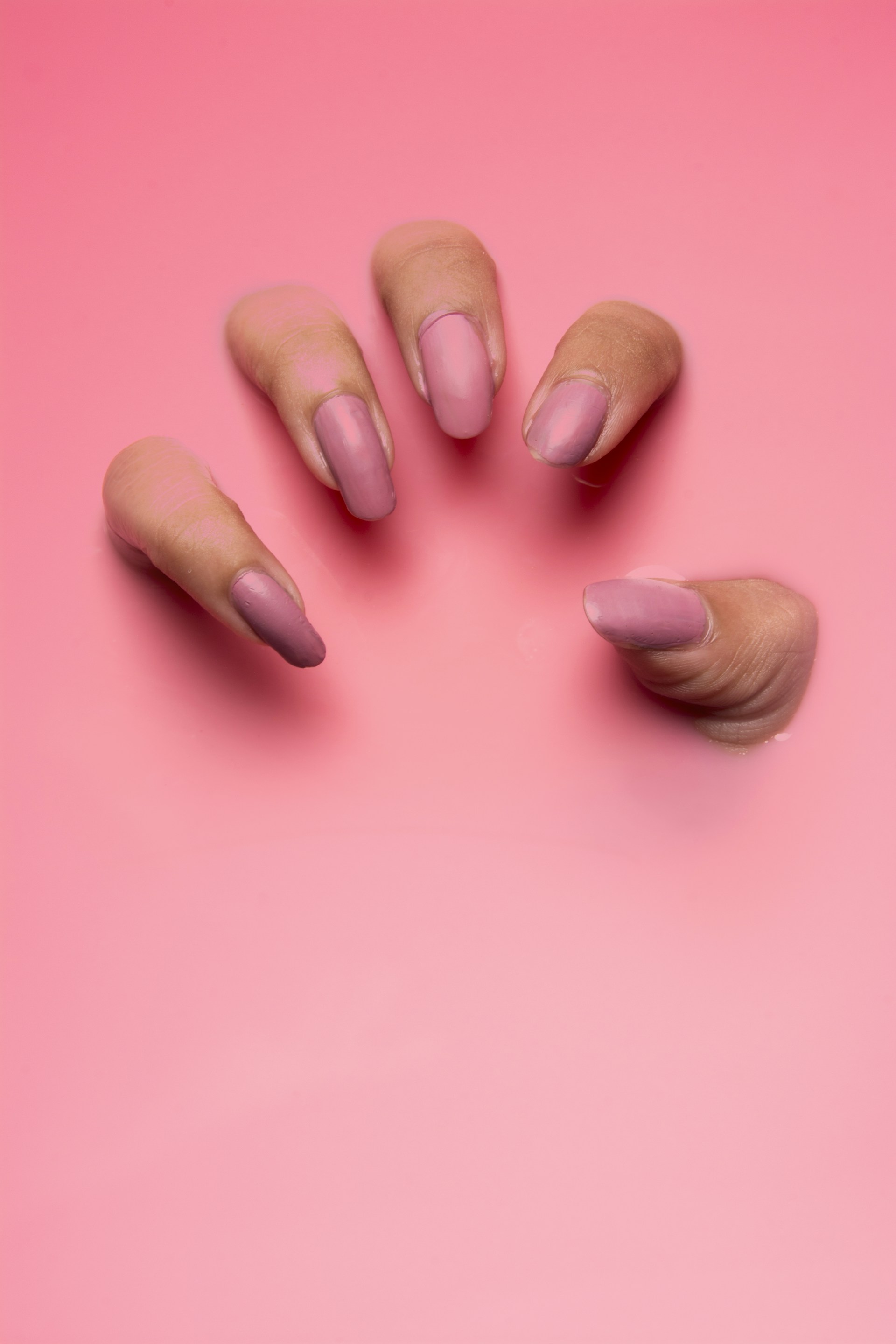 persons hand on pink surface