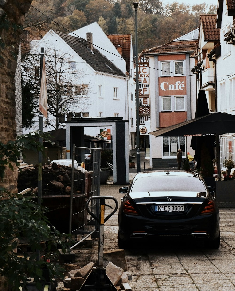 black car parked near green plants during daytime