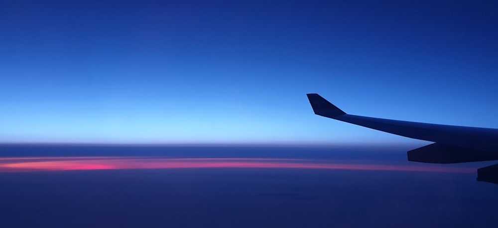 airplane wing under blue sky during daytime