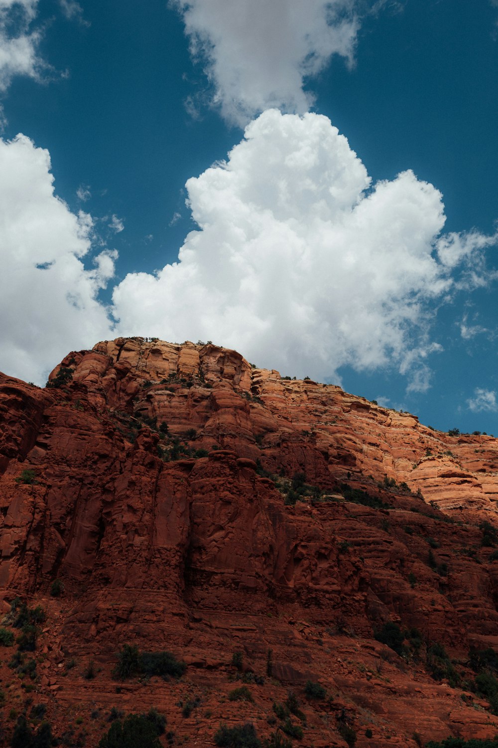 brown rocky mountain under blue sky and white clouds during daytime