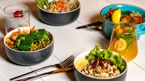 Colorful healthy ready-to-eat meals and beverages arranged on a wooden table.