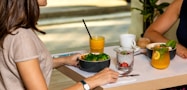 person holding black ceramic bowl with vegetable salad