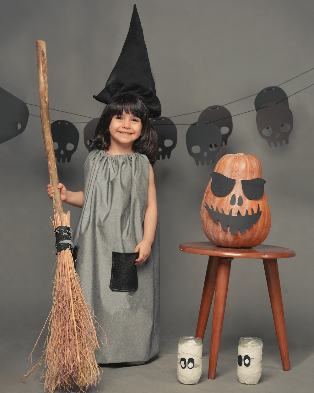 woman in black academic dress standing beside jack o lantern