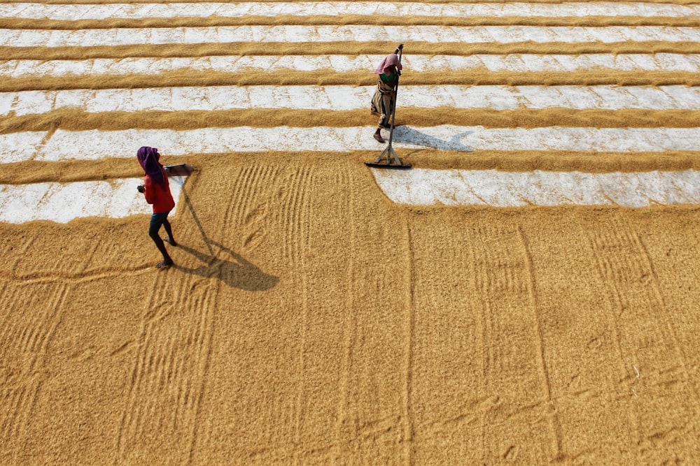 woman in red shirt walking on brown sand