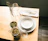 Close-up of elegant tableware pieces arranged on a rustic wooden table.
