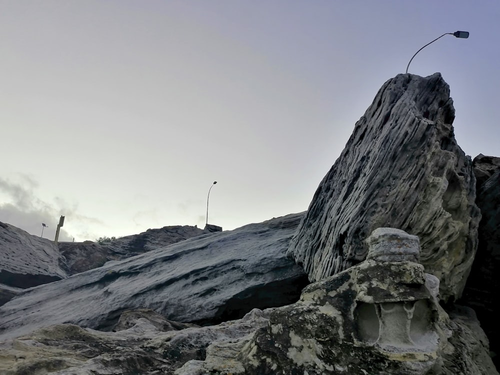 montagna rocciosa grigia sotto il cielo bianco durante il giorno
