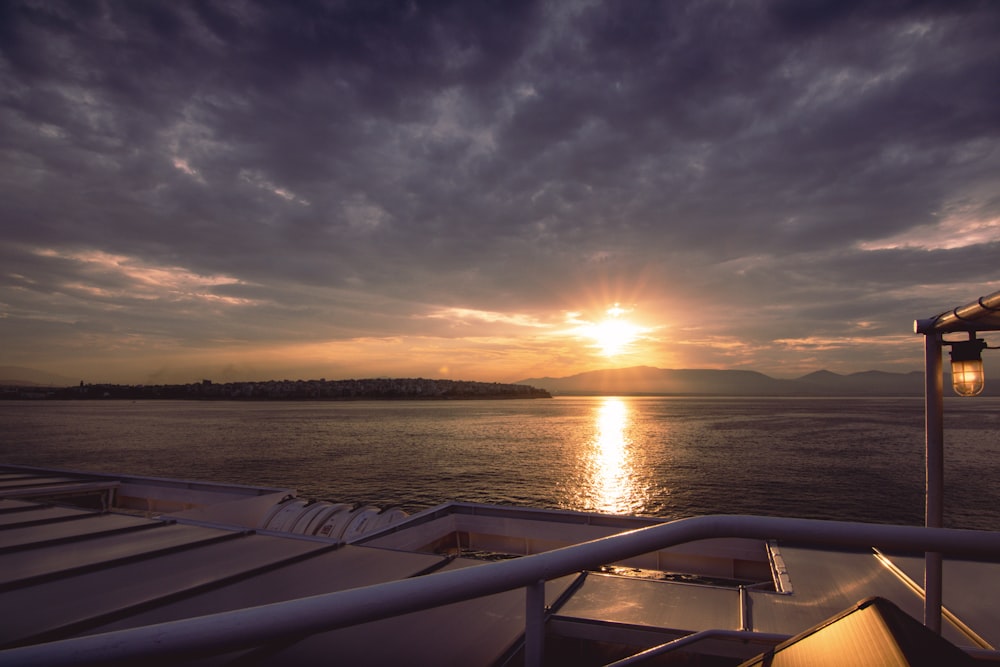 white boat on sea during sunset