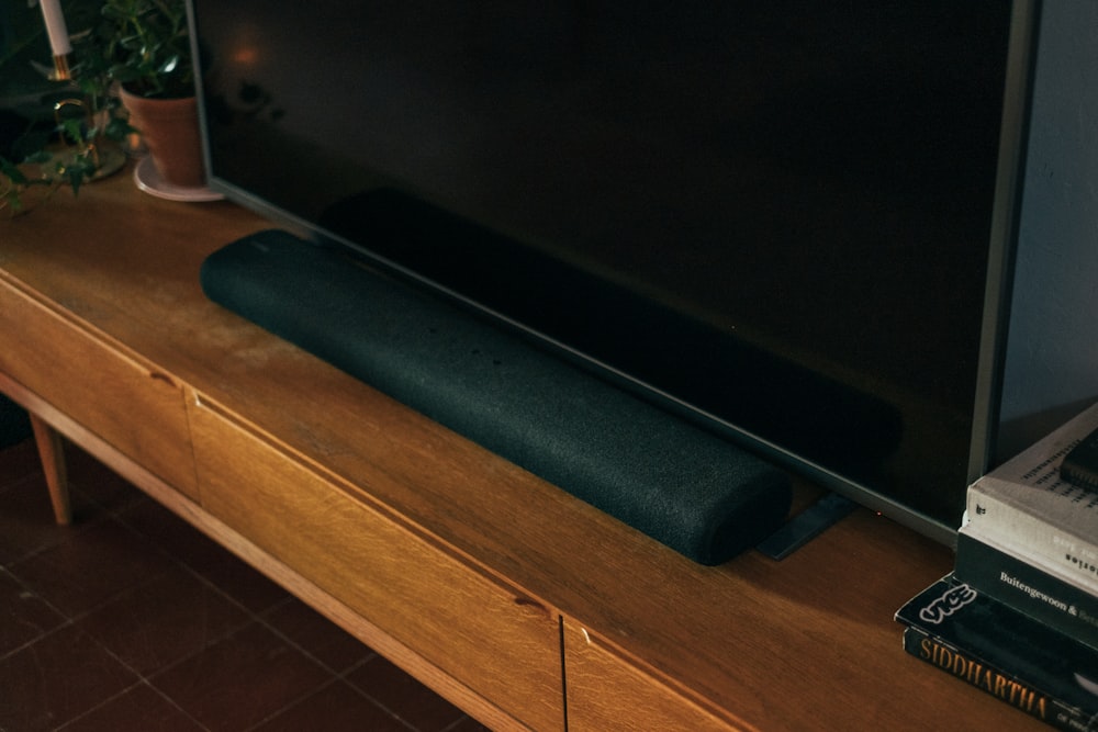 Televisor de pantalla plana negro sobre mesa de madera marrón